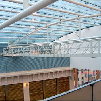 Aluminium hangbrug met telescopisch werkplatform gebruikt voor de onderhoud van een glazen plafond. Aluminium hangbrug met telescopisch werkplatform - Building Maintenance Unit